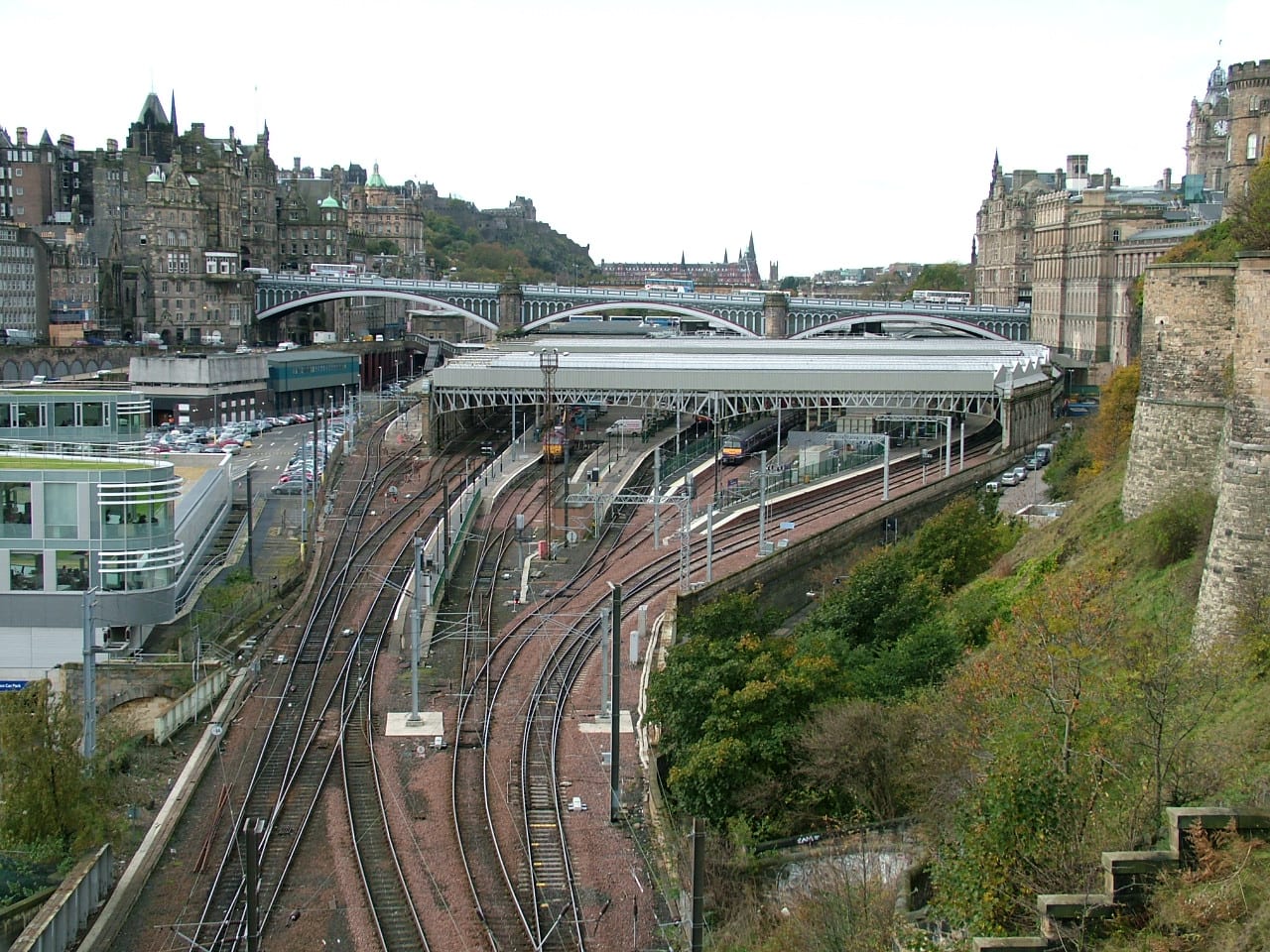 Aerial view of North Bridge spanning Edinburgh Waverley railway station, with the Old Town skyline behind.