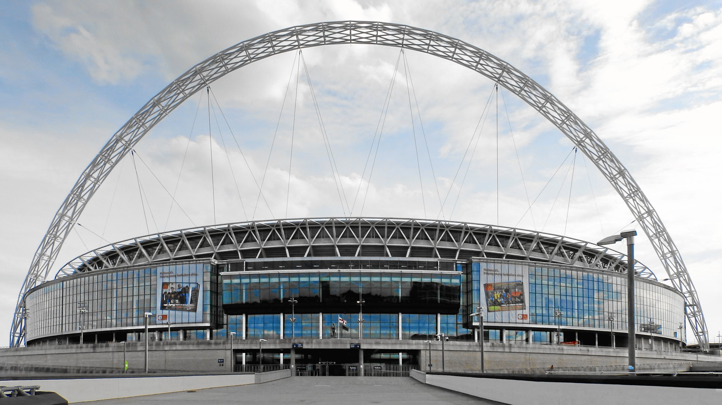 Exterior view of Wembley Stadium showing its distinctive arched roof structure.